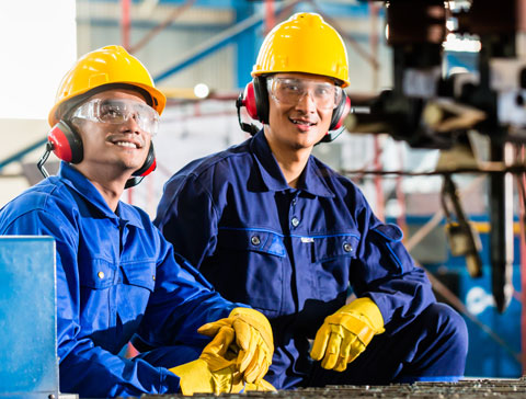 Arbeiter im Overall mit Helm und Gehörschutz